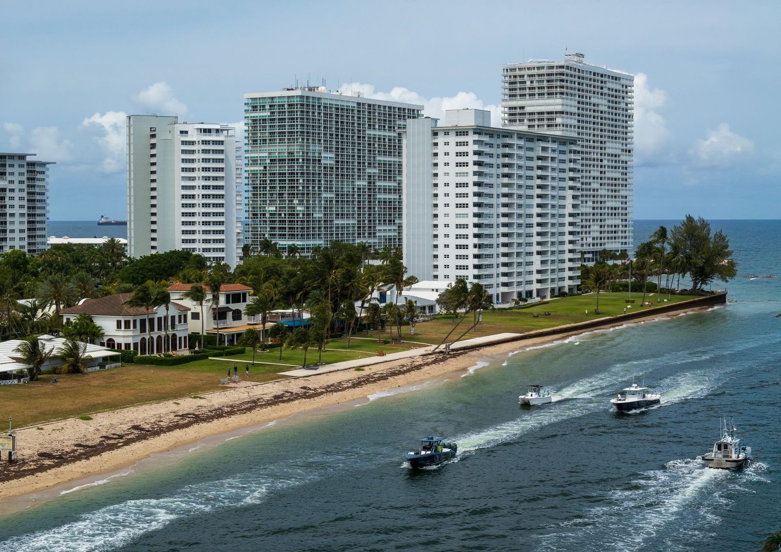 Vista aérea de rascacielos junto a la playa de Fort Lauderdale, con barcos sobre el agua.