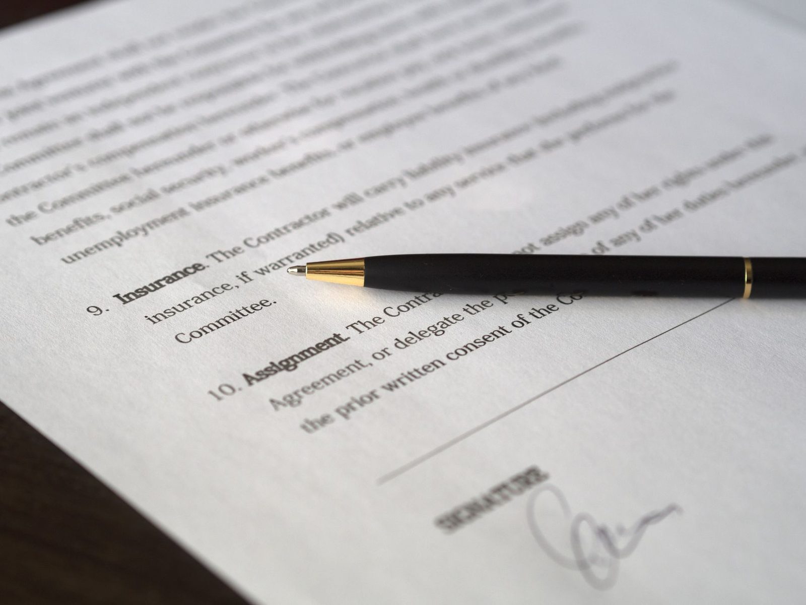 Hands signing a business contract with a pen, ready for agreement.