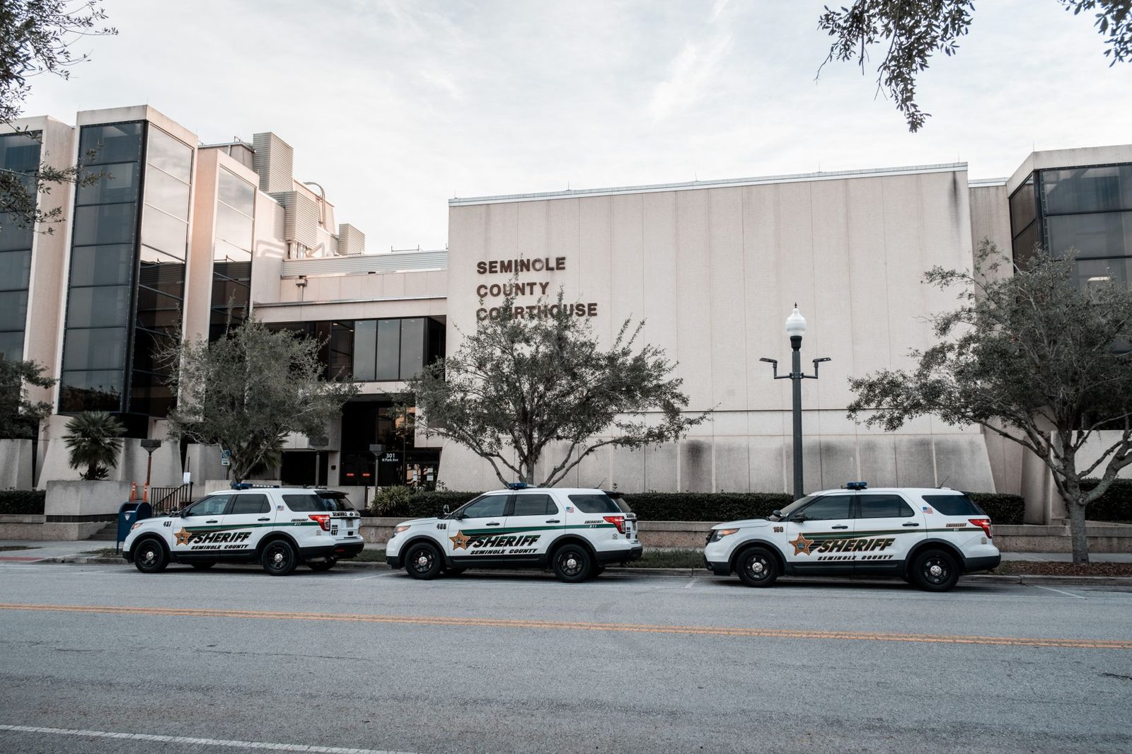 Sheriff vehicles parked in front of the Seminole County Courthouse during the day.
