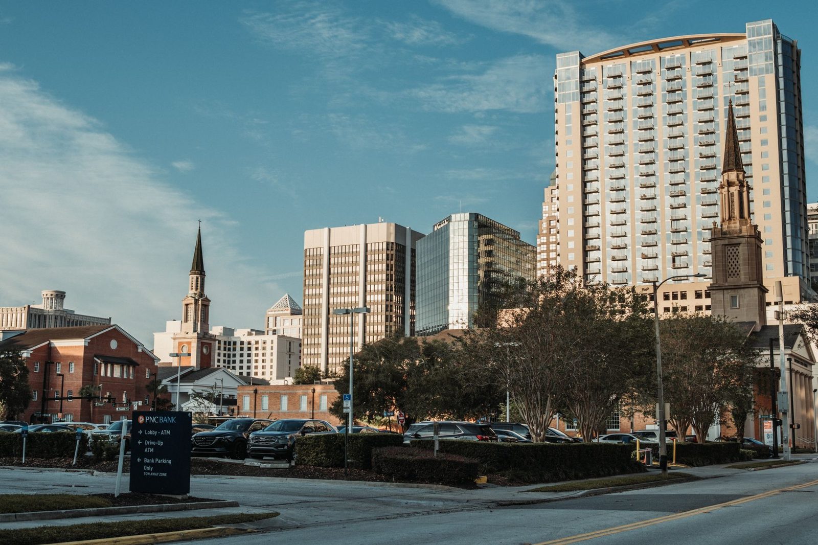 Tall city skyscrapers rise beneath a clear blue sky.