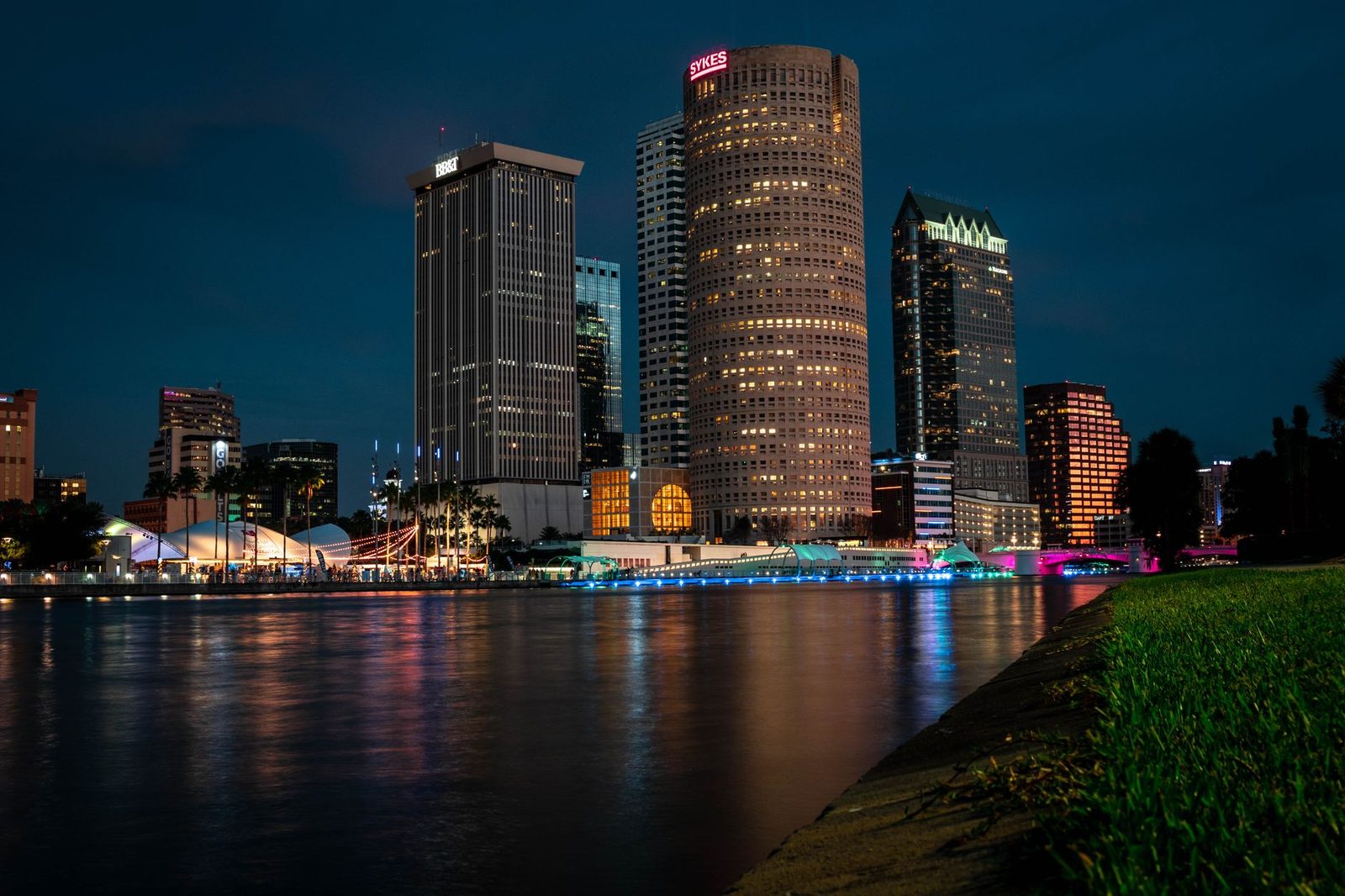 Tampa's skyline at evening, reflected on the calm river.