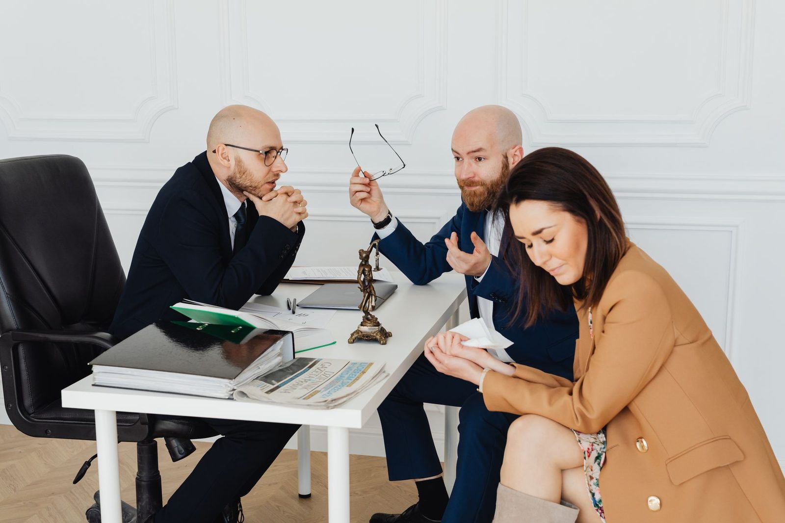Lawyers and frustrated clients sit at a conference table during a tense meeting in a law office.